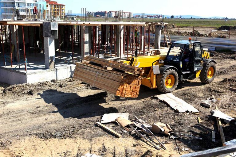 A construction crew sets panels and beams on a partially built single-family home under a bright sky.